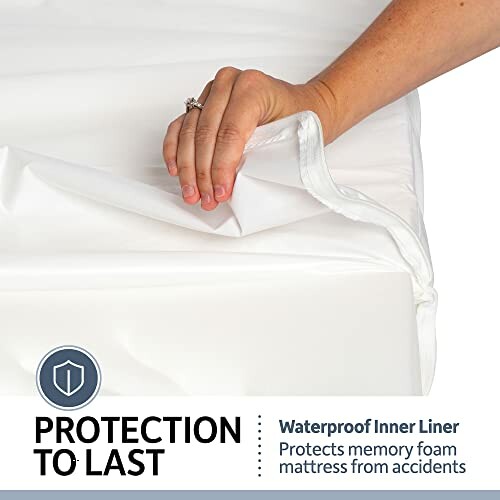 Hand placing waterproof inner liner on mattress.